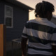 11-year old juvenile arrest for making threat in Tennessee: view of young black child from behind in horizontal striped shirt at dusk