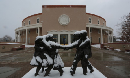 New Mexico passes new child protection law: statue of children playing outside New Mexico state Capitol in the snow