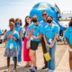 aviation education grant: group of girls in bright blue shirts standing in front of plane on tarmac