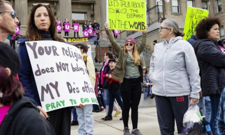 Bill to criminalize help for Idaho minors’ abortions passes: mostly female protesters holding signs in front of state government building