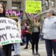 Bill to criminalize help for Idaho minors’ abortions passes: mostly female protesters holding signs in front of state government building