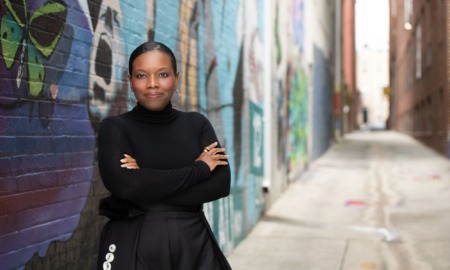 Candice Jones juvenile crime data: black woman wearing black standing in graffiti-ed alleyway with arms crossed