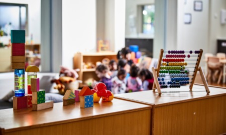 Daycare owners and parents say they are at a breaking point as federal relief funds end: daycare room seen from behind shelves with colorful toys on top