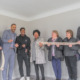 Can affordable housing make afterschool field fairer for workers: Group of people standing in empty room of house holding a banner while smiling