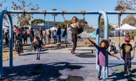 education research grants: kids playing on swingset on sunny day