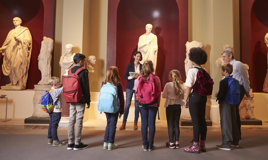 Education overhaul links kids to community spaces: young students and teacher at history museum