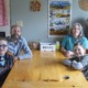 Families worry over future of medicaid caregiver payments: family sitting at wooden kitchen table smiling