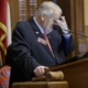 Georgia lawmakers hands transgender decision to sports group: frustrated older white man at podium rubbing forehead