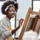 arts culture organization support grants: young black female artist working on painting