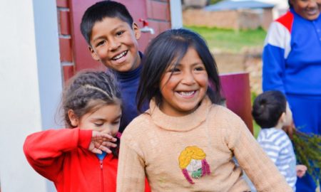 tribal college child care and welfare: happy native american children outside building