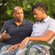 youth mentoring for preventing delinquency grants; man mentors young african american man on park bench