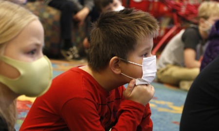 social emotional learning teaching: children on the floor with facemasks on listening to educator