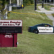 School triage training: Margory Stone Douglas High School sign on green lawn with police car in background