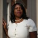 Merit scholarship racial inequities: Black woman with long black hair wearing white top and pearl necklace looks to her left