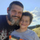 Child Death Weldare Distody: Man with brown hair ans frating beard stands close to young boy with brown hair both smiling into camera