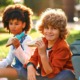 Free summer lunch: Two young children sit cross-legged on the grass eating sandwiches.