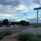 Diamond Ranch Shutdown: Several buildings surrounded by trees at the intersection of intersetrion of two roads under a blue sky with gray and white clouds.