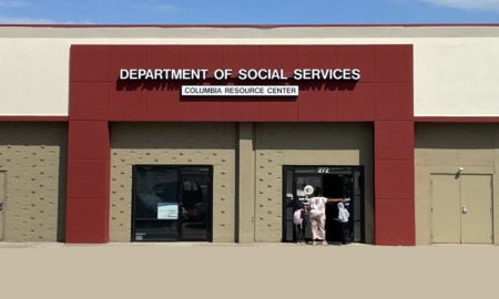 Missouri SNAP_ Red and tan commercial building under a blue sky with signage "Department of Social Services"