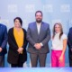 Mentoring month: 3 men and 2 women in business cloths stand in front of floor to ceiling light blue screen with white Hope Florida logo repeat printed across several rows