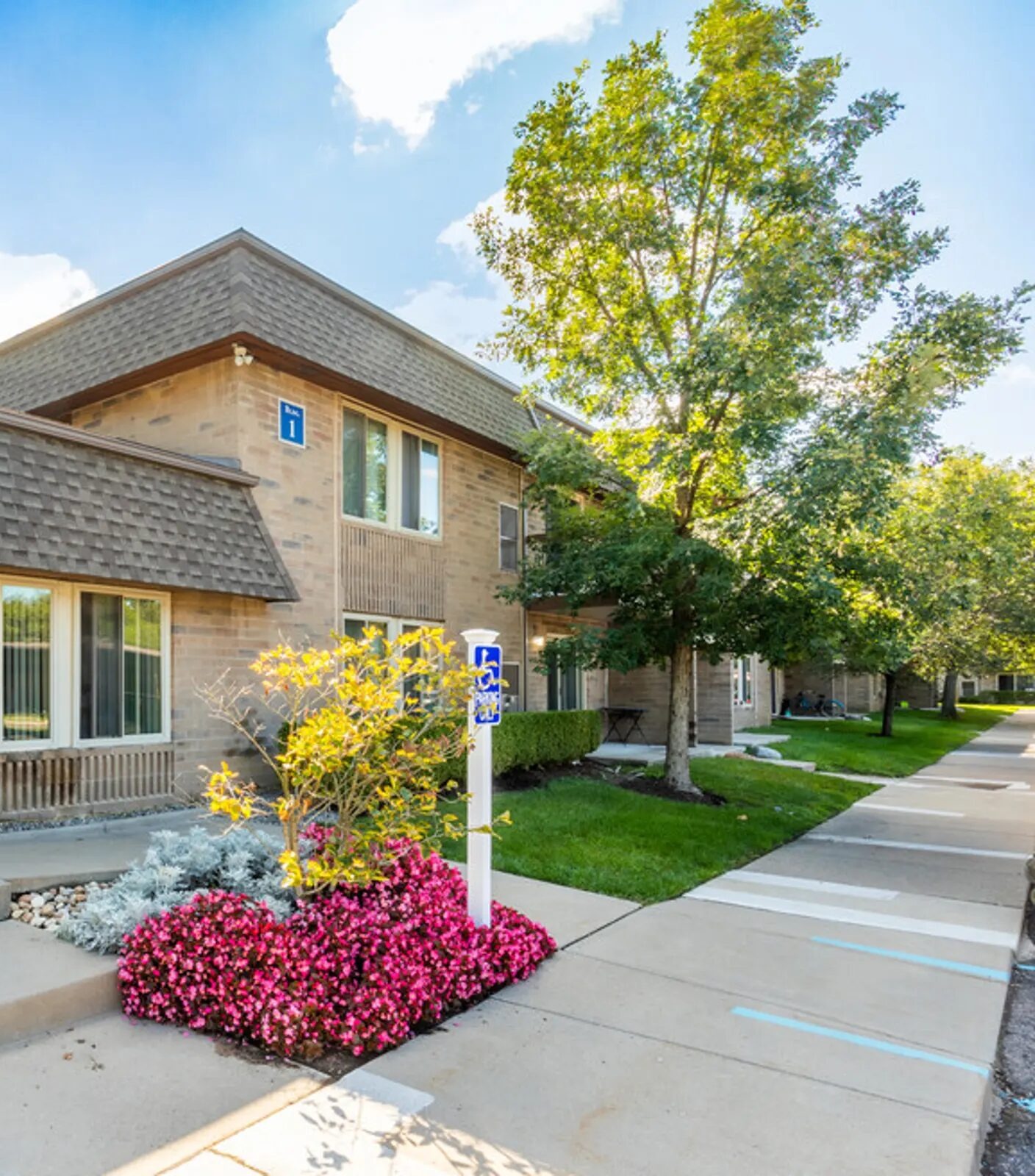 Sandra Birchwood justice: Multi-story, red brick apartment complex with trees and shrubbery