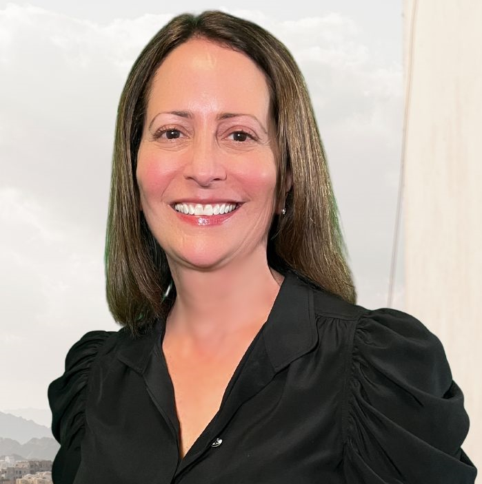 CA foster care shutdown: White woman with long dark hair in black blouse smiles widely into camera