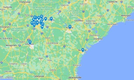 Georgia school violence map: Map of Georgia, US, and some surrounding east coast area in greens and yellows, next to light blue Atlantic Ocean, with darker blue map pins on locations of school violence incidents