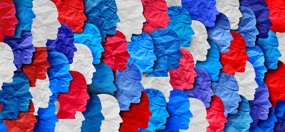 Civics teacher interview: Many red, white & blue human head profile silhouettes mad from slightly wrinkled paper set closely together and overlapping in four rows