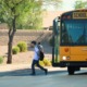 Arizona school vouchers: Elementary school kids getting off a big, yellow school bus and walking along a sidewalk away from camera