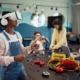 Teens and technology: Students in a school technology classroom using various gear like laptops, VR headsets, and building with electronic kits.