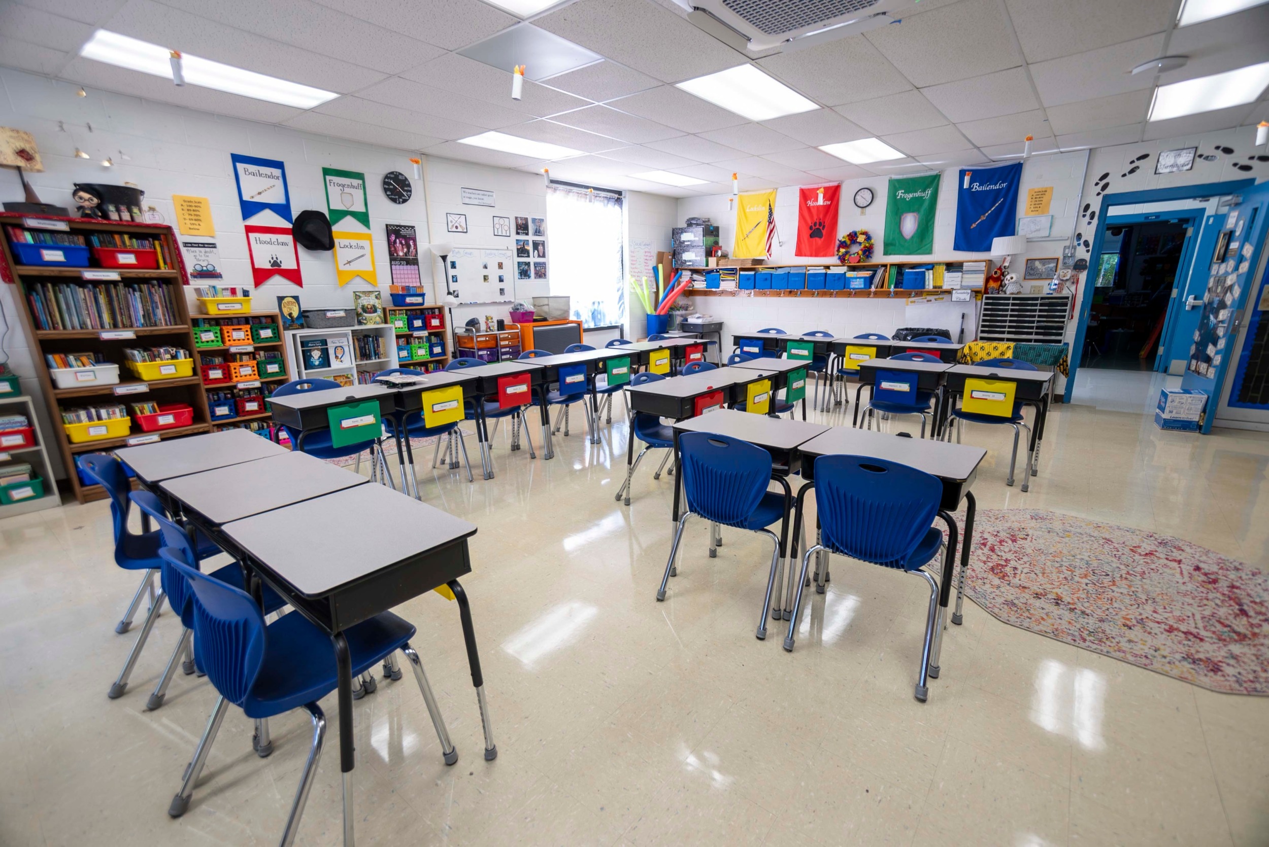 Absenteeism: Wide angle view of empty elementary school classroom with interactive whiteboard no people and lights turned on.