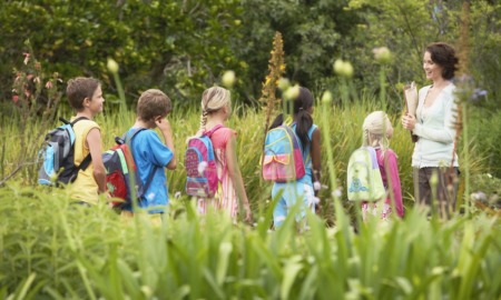 out-of-school time, outdoor learning grant: teacher and students in backpacks out in nature