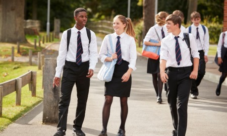 school choice, private schools push parents to exploit school voucher programs: group of private school students in uniform walking outside