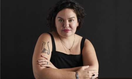 Roxanna Asgarian Q&A: woman with medium length dark hair whit arms folded on table against dark background