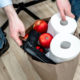 gun violence: A man holding a grocery shopping paper bag with toilet paper, apples, gun