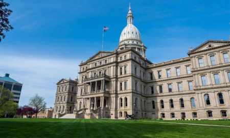 Some Michigan districts are not equitably funding schools with higher needs: view of Michigan capitol building from the front lawn with blue sky