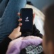 social media use, tiktok, youth mental health: young person laying down opening TikTok on phone