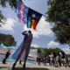 Texas judge blocks investigations of trans youth parents: protesters with flags on a partly cloudy day