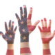 Civics education, youth leadership and civic engagement: raised hands of young people colored like american flag