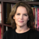 Nicola Diamond newsmaker headshot, brunette woman smiling at camera in front of bookshelves