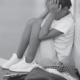 Ring the Alarm: Crisis of Black Youth Suicide Report; young, sad black girl sitting in corner with head in hands